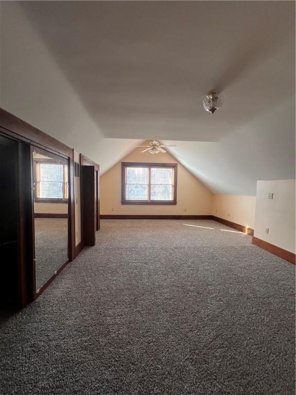 bonus room with a ceiling fan, lofted ceiling, baseboards, and carpet floors