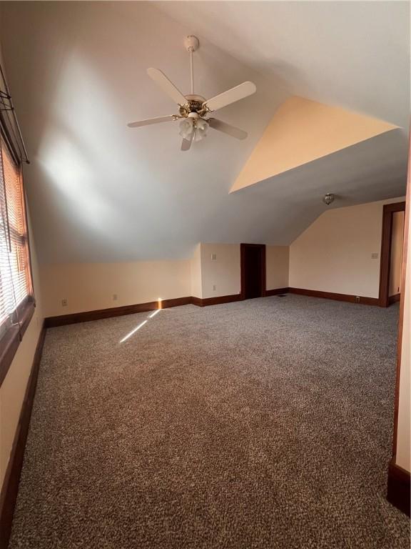 bonus room featuring carpet flooring, baseboards, ceiling fan, and vaulted ceiling