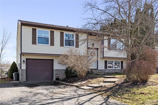 bi-level home featuring a garage and driveway