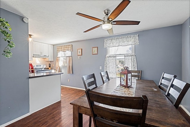 dining space featuring dark wood finished floors, a textured ceiling, baseboards, and ceiling fan