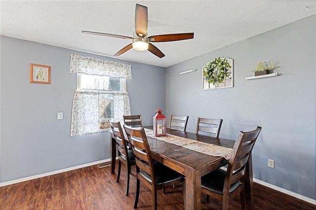 dining room featuring visible vents, baseboards, wood finished floors, and a ceiling fan