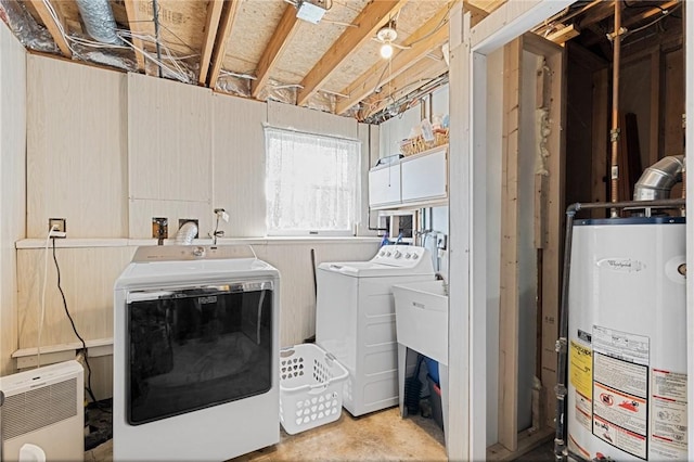 clothes washing area with washer and dryer, gas water heater, and laundry area