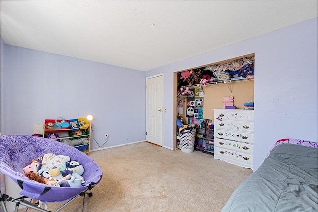 carpeted bedroom featuring a closet and baseboards