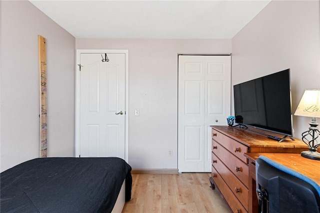 bedroom with light wood-style flooring and baseboards