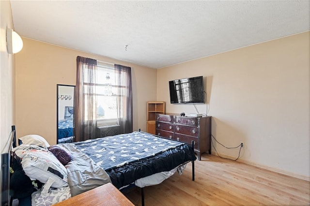 bedroom featuring baseboards and wood finished floors