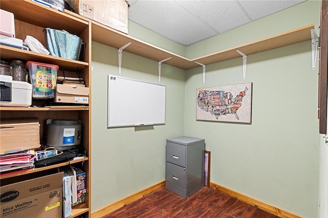 home office featuring a drop ceiling, dark wood-type flooring, and baseboards