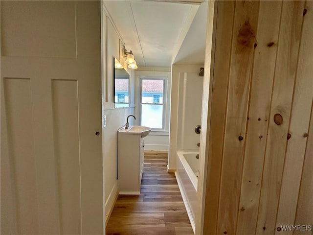 bathroom with vanity, wood finished floors, and shower / bathtub combination