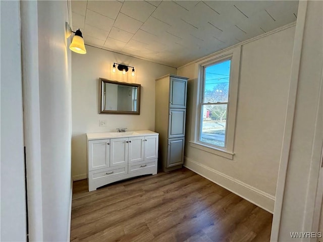 bathroom featuring vanity, wood finished floors, and baseboards