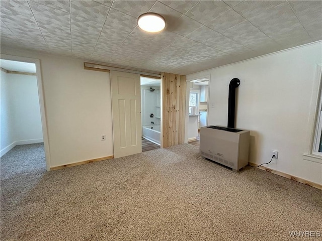 interior space with heating unit, carpet, and baseboards