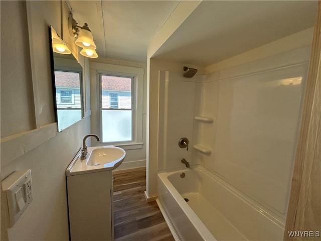 full bath with vanity, bathing tub / shower combination, wood finished floors, and baseboards