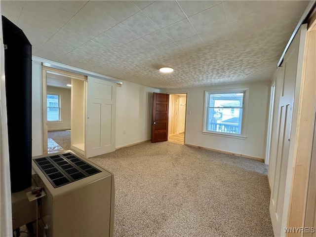 unfurnished bedroom with multiple windows, light colored carpet, and baseboards