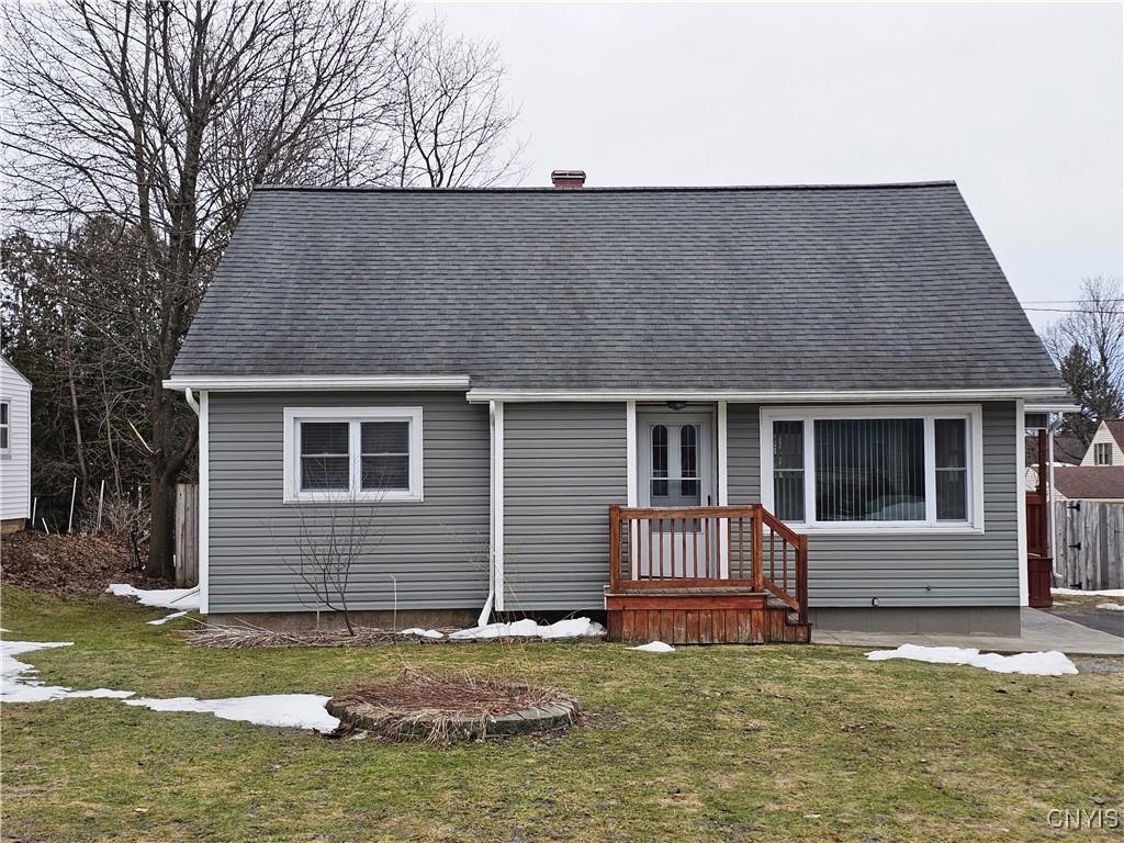 view of front facade featuring a front lawn and a shingled roof