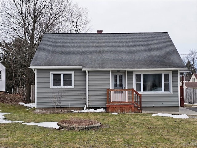 view of front facade featuring a front lawn and a shingled roof