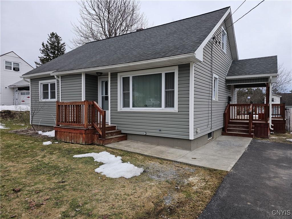 view of front of property with a front yard and roof with shingles