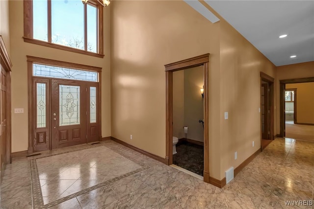 entrance foyer featuring a high ceiling, recessed lighting, baseboards, and marble finish floor