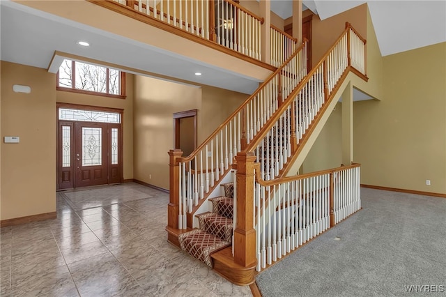 foyer entrance featuring stairway, baseboards, carpet floors, a high ceiling, and recessed lighting