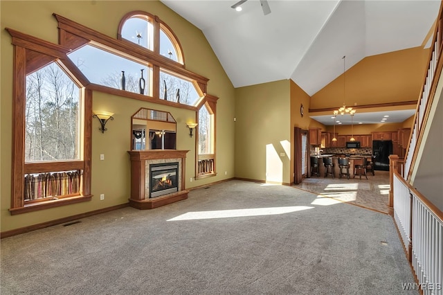 unfurnished living room featuring light carpet, a healthy amount of sunlight, visible vents, and a tile fireplace