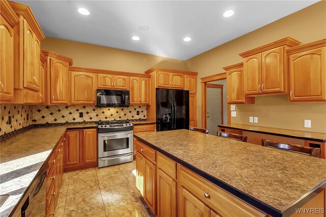 kitchen featuring recessed lighting, tasteful backsplash, black appliances, and a center island