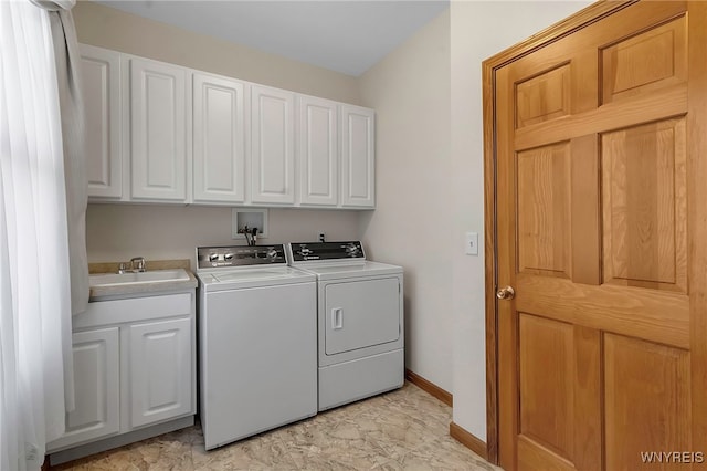 laundry area with washing machine and dryer, cabinet space, baseboards, and a sink