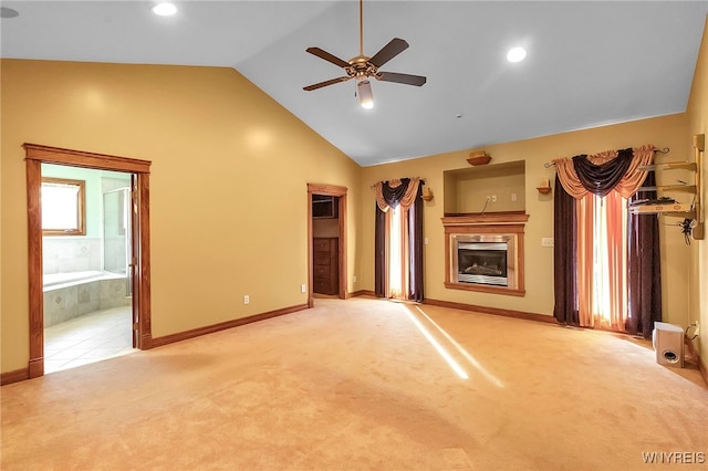 unfurnished living room with high vaulted ceiling, carpet, a fireplace, baseboards, and ceiling fan