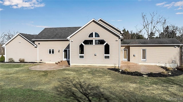 back of property with a yard, entry steps, and a patio area