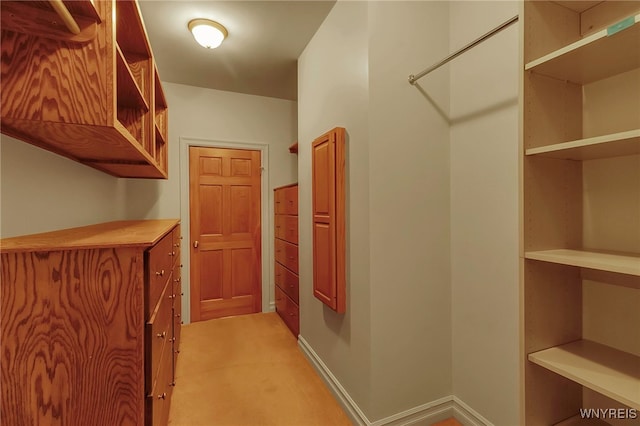 hall with light colored carpet and baseboards