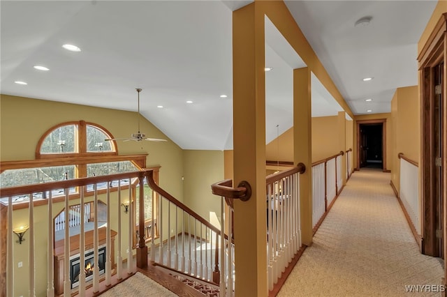 corridor with lofted ceiling, recessed lighting, carpet, and an upstairs landing