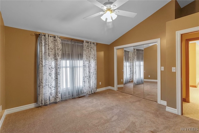 unfurnished bedroom with lofted ceiling, multiple windows, carpet flooring, and a closet