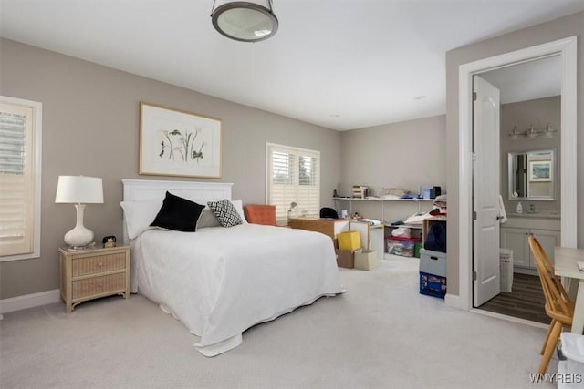 bedroom with baseboards, ensuite bathroom, and carpet flooring