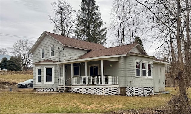 view of front of home featuring crawl space, a porch, a shingled roof, and a front lawn