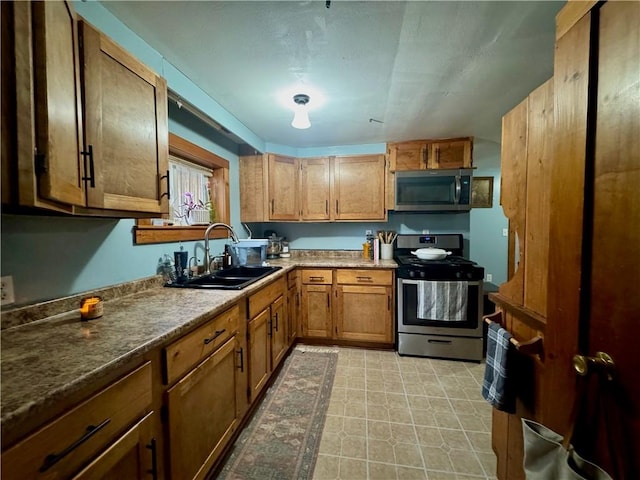 kitchen featuring brown cabinets, appliances with stainless steel finishes, and a sink