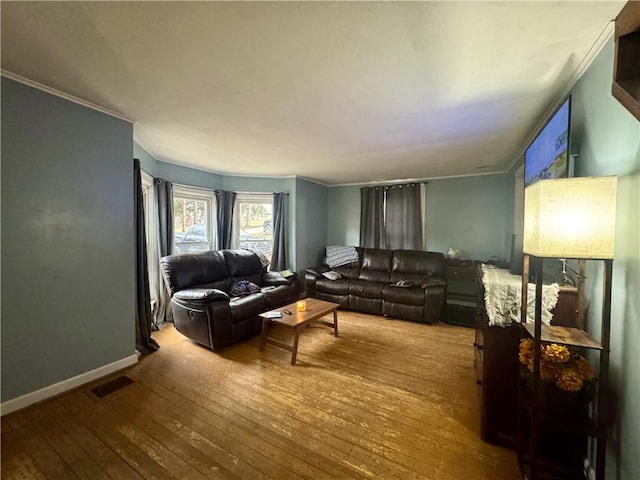 living area with visible vents, ornamental molding, baseboards, and hardwood / wood-style flooring