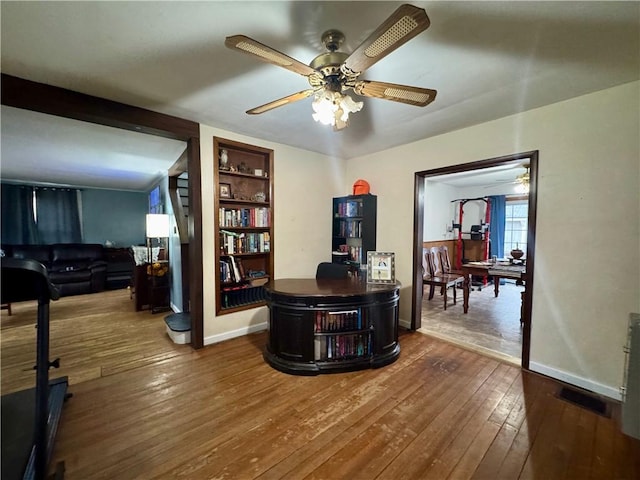 home office featuring visible vents, baseboards, ceiling fan, and dark wood-style flooring