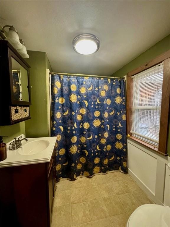 bathroom with toilet, vanity, and a shower with shower curtain