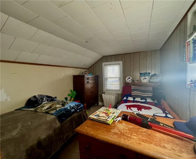 bedroom with vaulted ceiling and wood walls