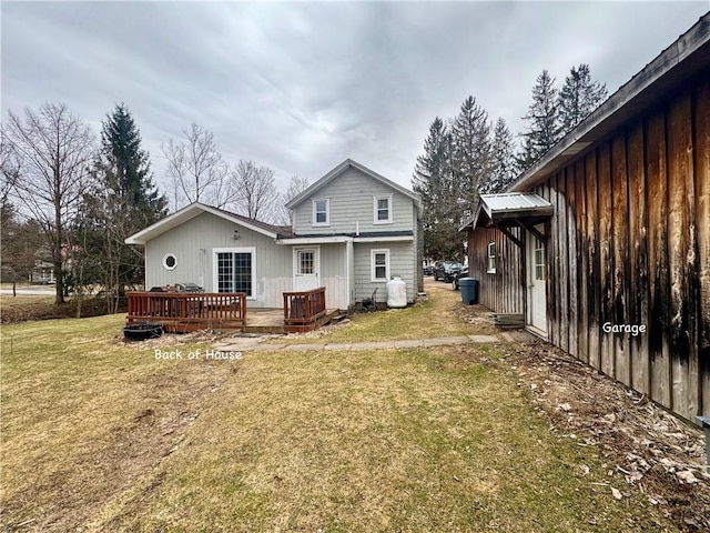 back of property featuring a lawn, board and batten siding, and a wooden deck