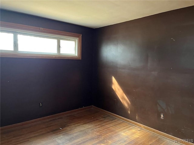 empty room featuring wood finished floors and baseboards