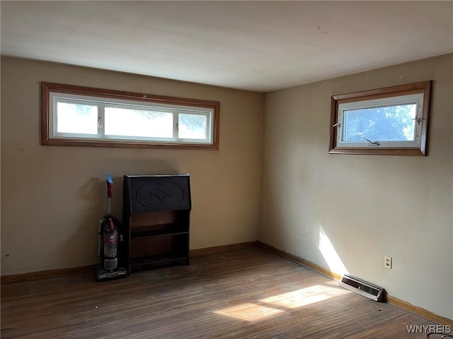 unfurnished room featuring wood finished floors, visible vents, and baseboards