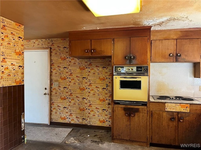 kitchen with brown cabinets, electric cooktop, and oven