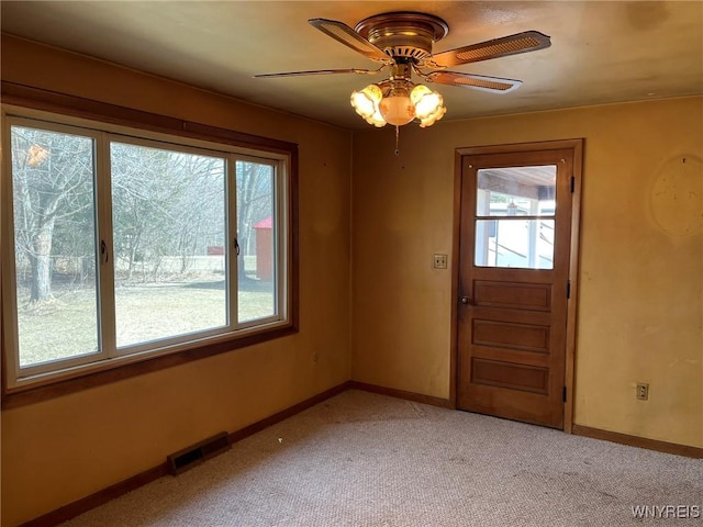 interior space with visible vents, a healthy amount of sunlight, light colored carpet, and baseboards