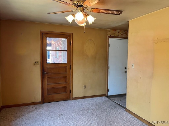 entryway with carpet, a ceiling fan, and baseboards