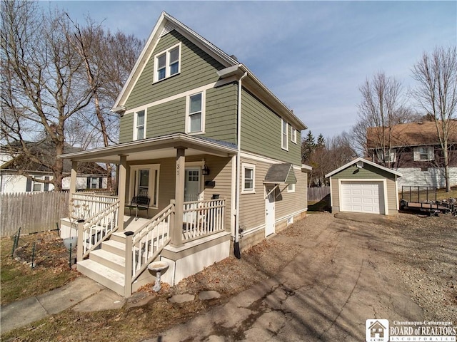 view of front of house with fence, dirt driveway, a porch, a garage, and an outdoor structure