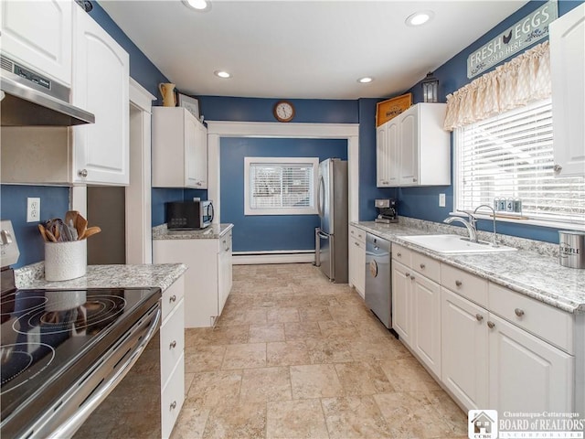 kitchen featuring a baseboard heating unit, under cabinet range hood, appliances with stainless steel finishes, white cabinets, and a sink