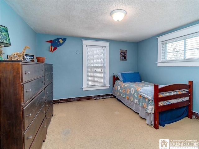 bedroom featuring baseboards, a textured ceiling, and carpet