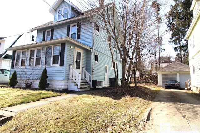 american foursquare style home with a detached garage, an outbuilding, and entry steps