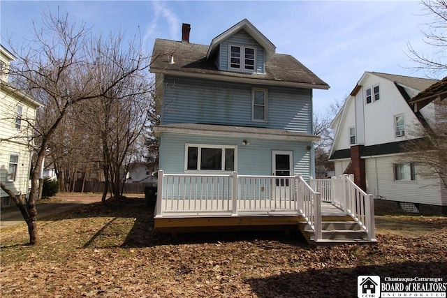 rear view of house with a wooden deck and a chimney