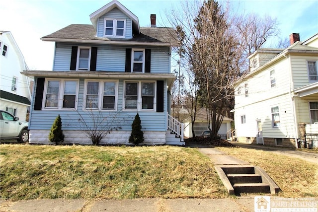 american foursquare style home featuring a front lawn