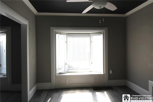 unfurnished room featuring visible vents, crown molding, a ceiling fan, and wood finished floors