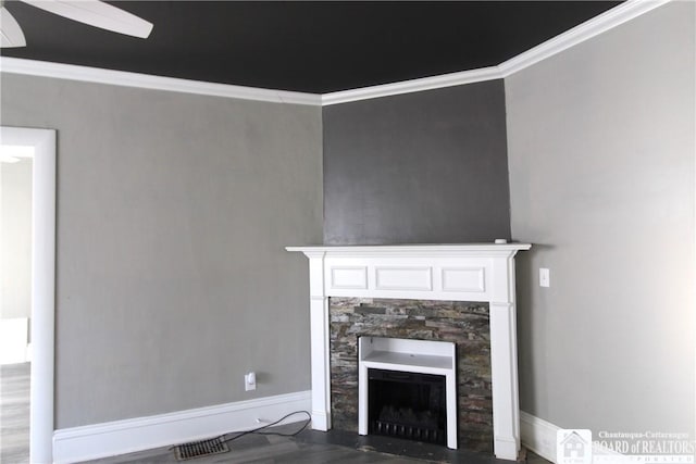 unfurnished living room with a fireplace with flush hearth, wood finished floors, baseboards, and ornamental molding