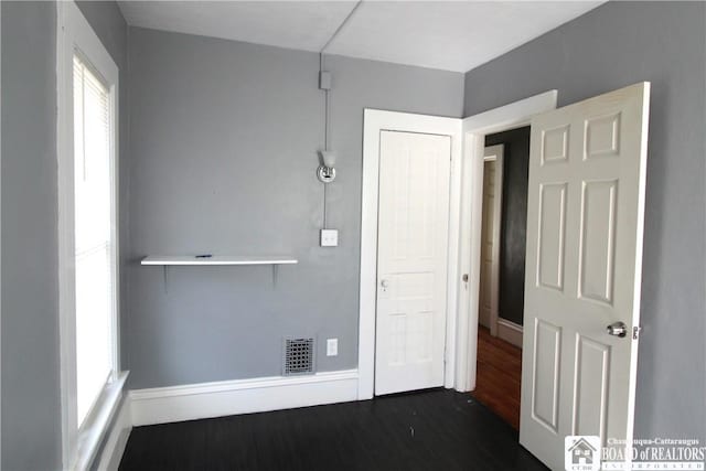 hallway featuring dark wood finished floors and visible vents